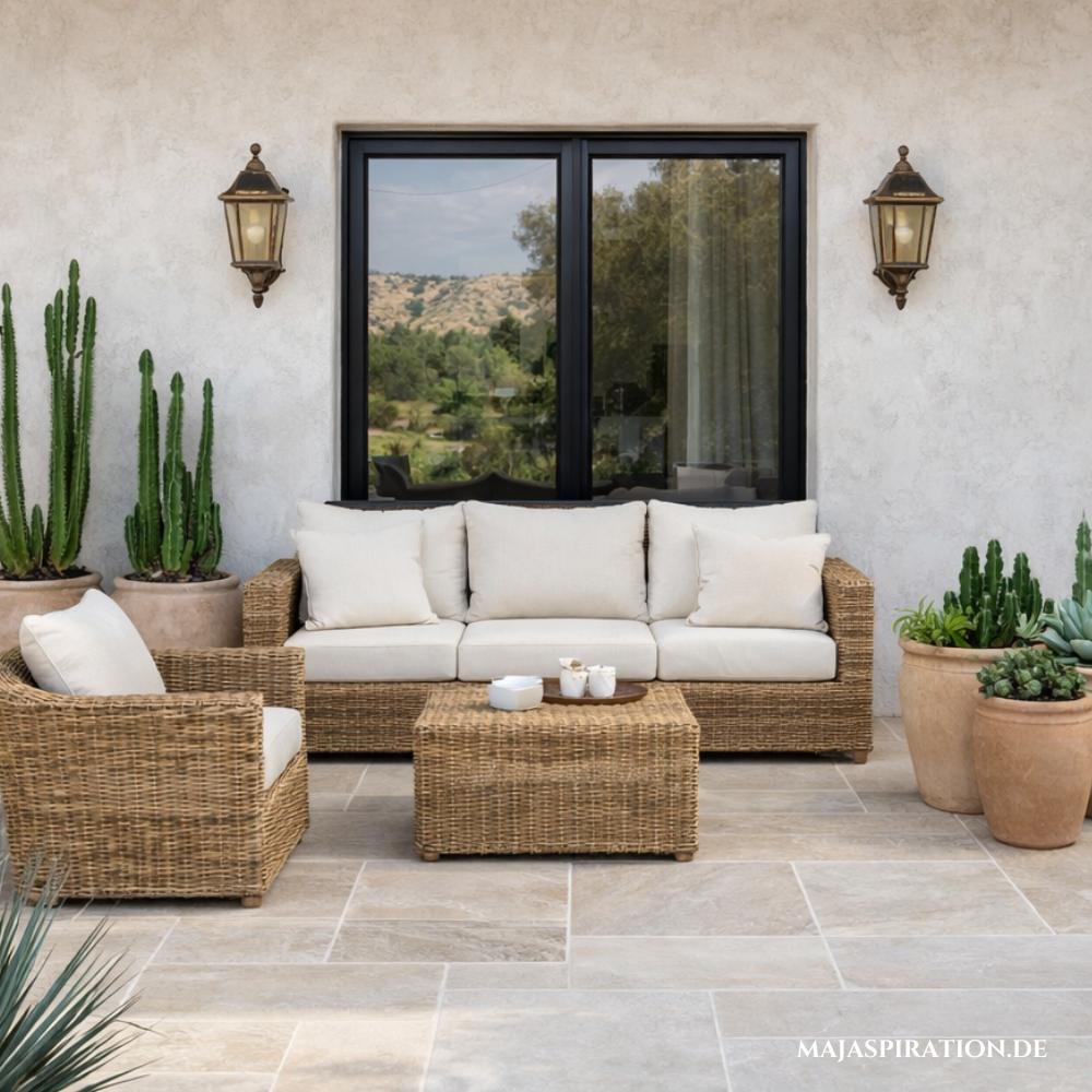 Mediterrane Terrasse mit Fliesen, Rattanmöbeln, Kakteen in Terrakotta-Töpfen und Wandleuchten