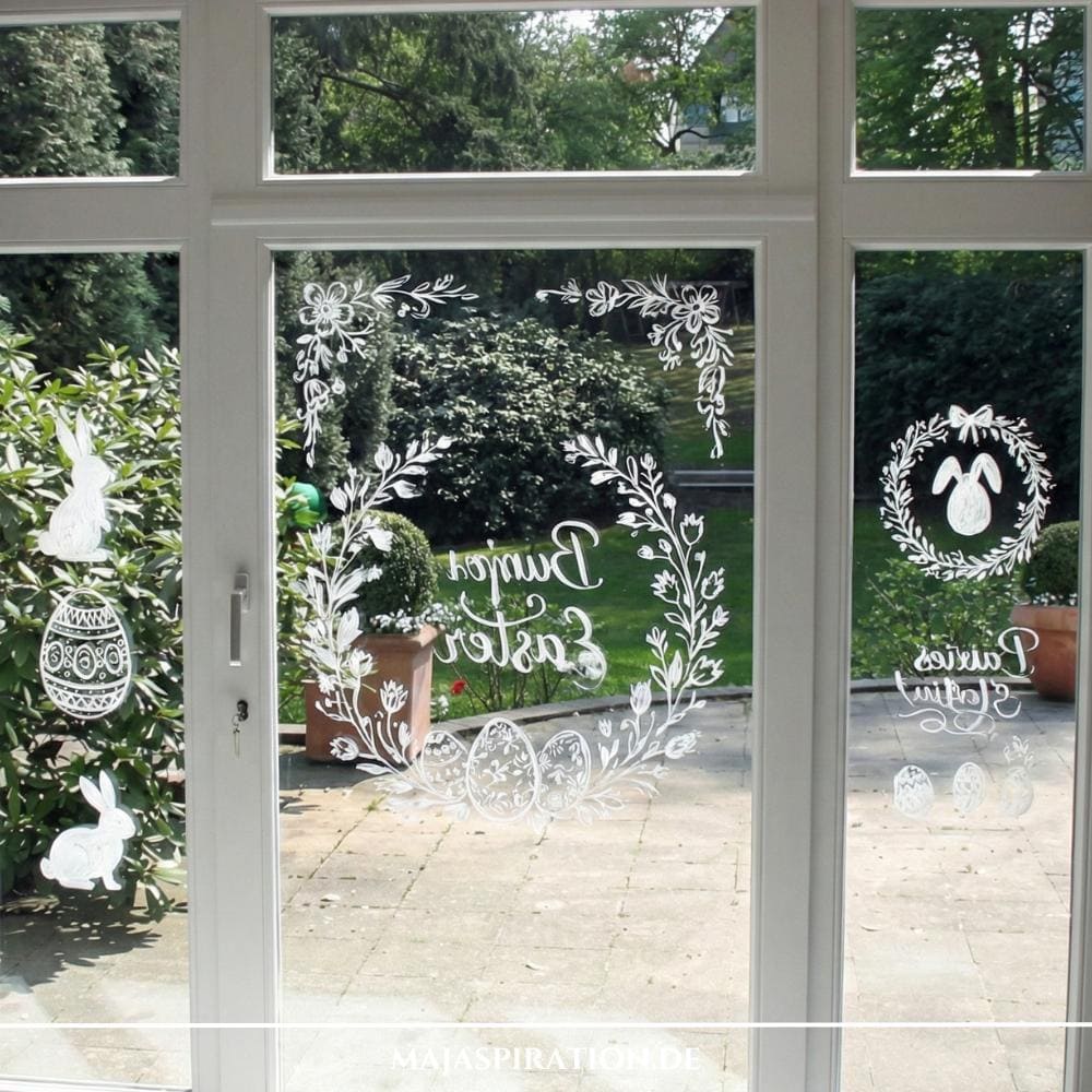 Österliche Fensterdekoration mit weißer Kreidefarbe-Zeichnungen auf Scheibe