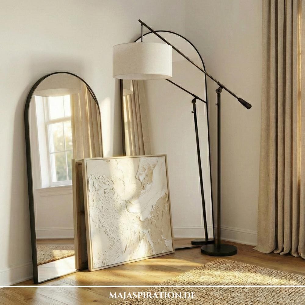 Gestaltungsidee für leere Ecken mit layered Wandspiegeln und einer Leinwand neben großer Bogenlampe